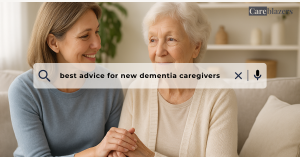Middle-aged daughter holding her elderly mother’s hand on the sofa, showing love and support, symbolizing the best advice for new dementia caregivers.