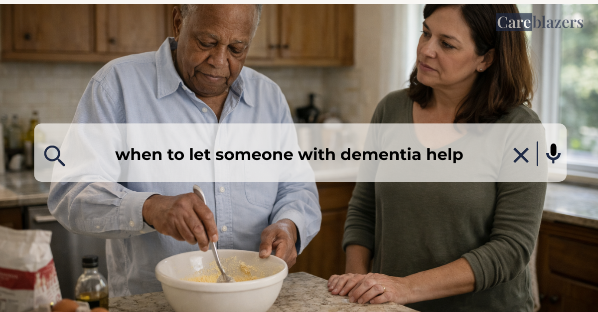 Older man stirring batter in a kitchen bowl while a middle-aged caregiver stands beside him, watching attentively in a softly lit home kitchen.