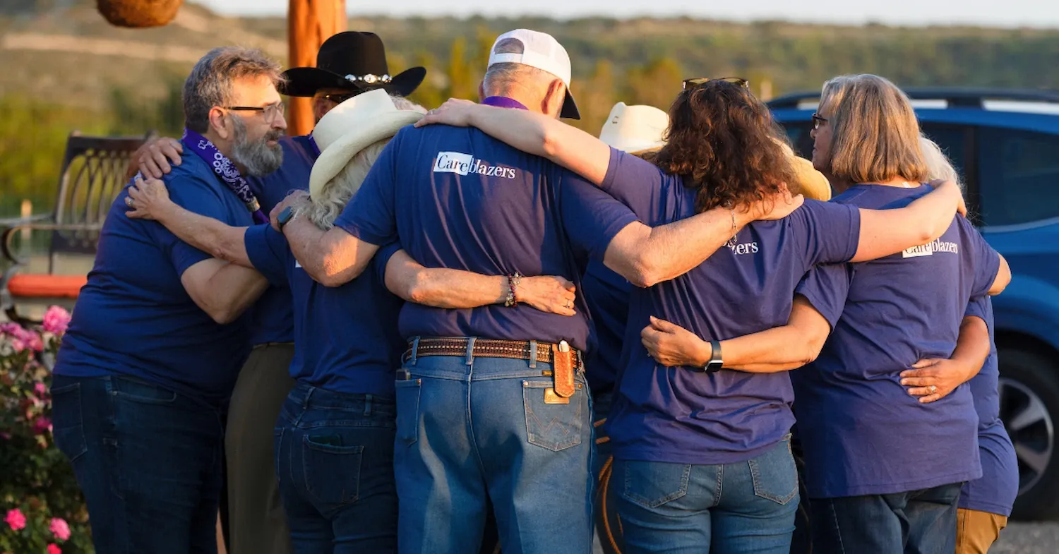 Careblazers with their arms around each other at an in-person gathering