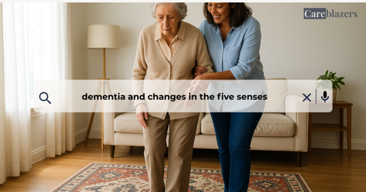 Middle-aged woman gently supporting an older woman as they walk across a patterned rug in a bright living room, helping her navigate the flooring safely. Both appear calm and focused, highlighting the visual–spatial challenges common in dementia.