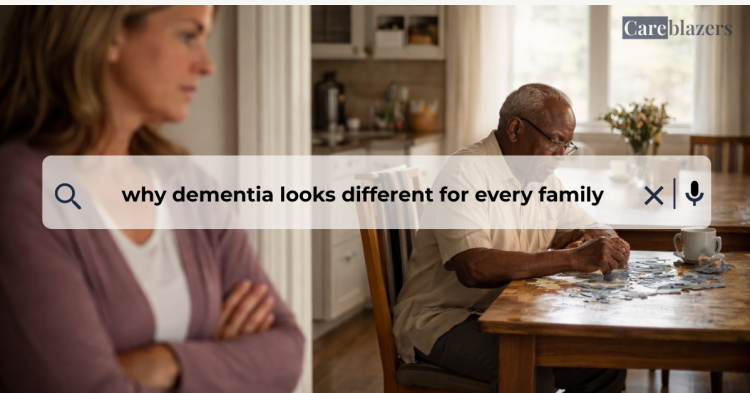 Older adult seated at a kitchen table working on a puzzle while a caregiver stands nearby in a calm home setting, showing quiet support and presence.